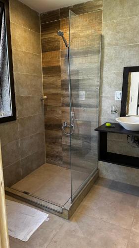 a shower stall in a bathroom with a sink at Tiny House Chacras in Chacras de Coria