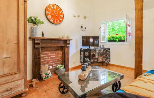 a living room with a fireplace and a clock on the wall at Awesome Home In Alette With Wifi in Alette