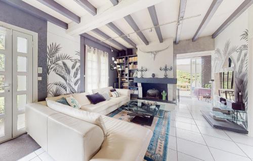 a living room with a white couch and a fireplace at Cozy Home In Angresse in Angresse