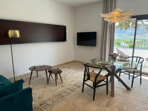 a living room with a table and chairs and a tv at CASA YANGUAS APARTAMENTOS RURALES EN LAUJAR DE ANDARAx in Laujar de Andarax
