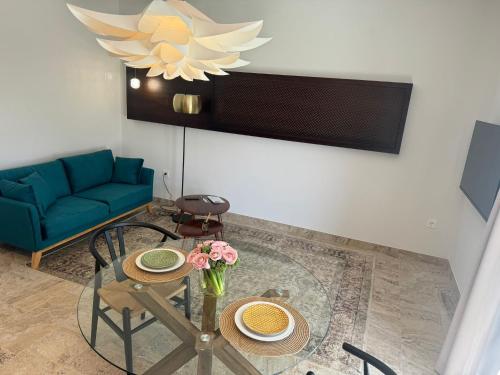 a living room with a table and a blue couch at CASA YANGUAS APARTAMENTOS RURALES EN LAUJAR DE ANDARAx in Laujar de Andarax