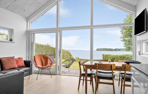 Una sala de estar con una mesa y sillas y una gran ventana. en Awesome Home In Hejls, en Hejls