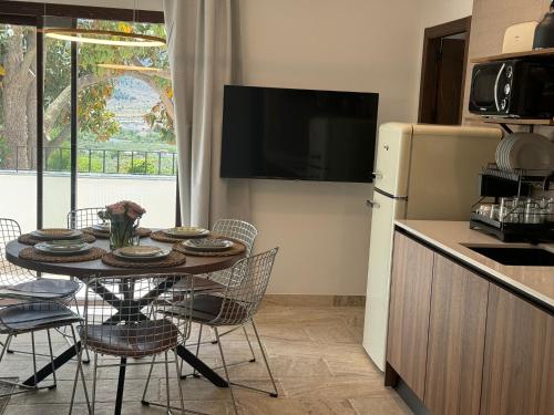 a kitchen with a table with chairs and a refrigerator at CASA YANGUAS APARTAMENTOS RURALES EN LAUJAR DE ANDARAx in Laujar de Andarax