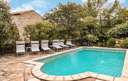 une piscine avec des chaises longues à côté d'une maison dans l'établissement Nice Home In Faugères, à Faugères