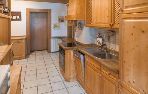 a kitchen with wooden cabinets and a sink at Nice Home In Bayerisch Eisenstein in Regenhütte