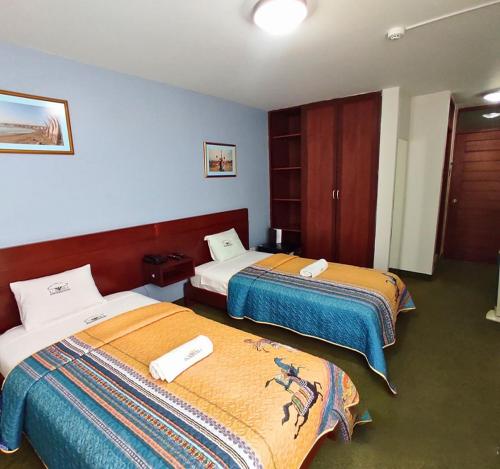 ein Hotelzimmer mit 2 Betten in einem Zimmer in der Unterkunft Hotel Korianka in Trujillo