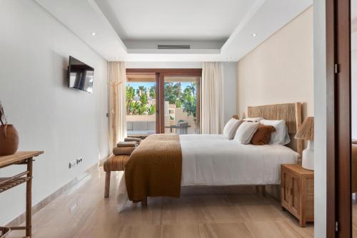 Un dormitorio con una cama grande y una ventana. en Penthouse Bahia de la Plata, en Estepona