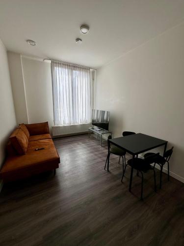 a living room with a couch and a table at 86 3City Appartement met Privé parkeerplaats in Enschede