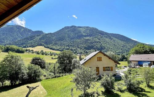 une maison dans un champ avec des montagnes en arrière-plan dans l'établissement Chez Barthoux, à Seythenex