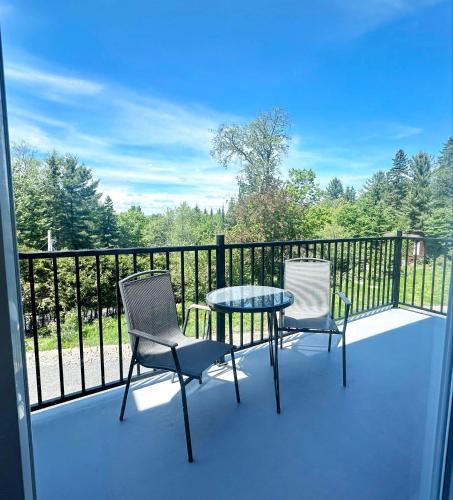 a patio with two chairs and a table on a balcony at Le domaine du Sous-Bois in Mont-Blanc