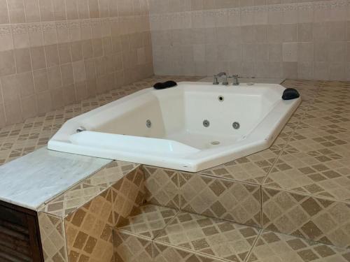 uma banheira branca numa casa de banho em azulejo em Hotel Sol em Termas de Rio Hondo