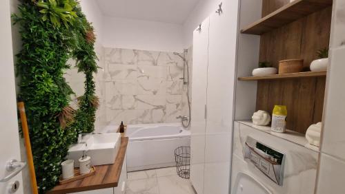 a bathroom with a white tub and a green wall at Appartment Chindia Lake in Târgovişte