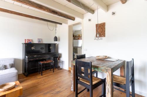 a living room with a table and a piano at Stijlvol & lief onthaast-huisje met piano, tv en wifi in Holwerd