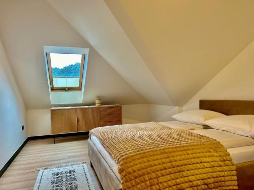 a attic bedroom with two beds and a window at Willa Asia in Sromowce Niżne