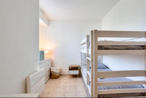 une chambre avec deux lits superposés et une salle de bain dans l'établissement Appartement T3 climatisé avec piscine et plages à pied, à Saint-Raphaël