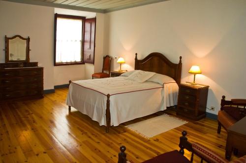 a bedroom with a bed and a dresser and a mirror at Solar dos Caldeira e Bourbon in Zebras