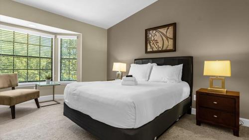 a bedroom with a large bed and a chair at Sunny Stay in FL - 4-Bedroom Townhome by Disney! in Orlando