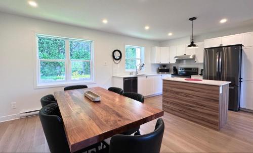 a kitchen with a wooden table and a dining room at Le domaine du Sous-Bois in Mont-Blanc