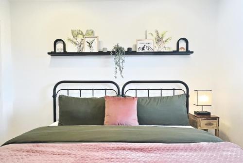 a bedroom with a bed with a pink pillow at Le domaine du Sous-Bois in Mont-Blanc