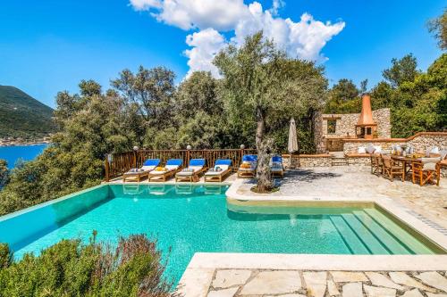 una imagen de una piscina con sillas y una casa en Villa Pisti, en Sivota