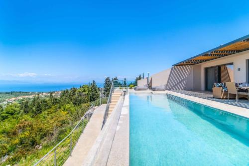 a swimming pool with a view of the ocean at Villa Andromeda Sunset in Tsoukaladhes