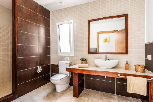 W łazience znajduje się toaleta, umywalka i lustro. w obiekcie Villa Satalaia w mieście Sant Lluis