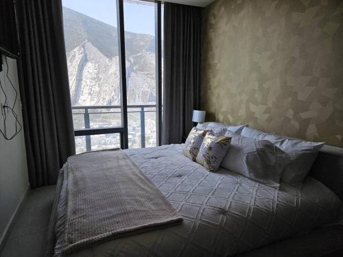 a bedroom with a bed with a view of a mountain at A 7 Minutos de San Pedro Lujoso Penthouse in Monterrey