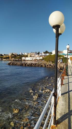 a street light next to a body of water at Sea View And Mountain View Apartment For 4 People in Makry Gialos