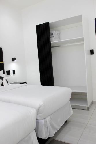 a bedroom with two white beds and a black headboard at Esteem guesthouse Windhoek in Windhoek