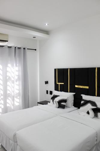 two beds in a bedroom with white walls at Esteem guesthouse Windhoek in Windhoek
