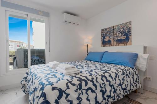een slaapkamer met een bed met blauwe en witte lakens bij City apartment Puerto Banus in Marbella