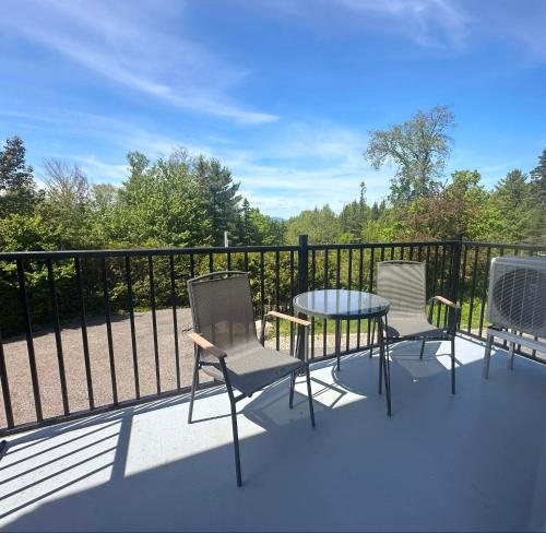 a balcony with a table and chairs and a fence at Le domaine du Sous-Bois in Mont-Blanc