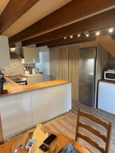 una cucina con frigorifero e tavolo in legno di Brittany Vacation Rental a Plomelin