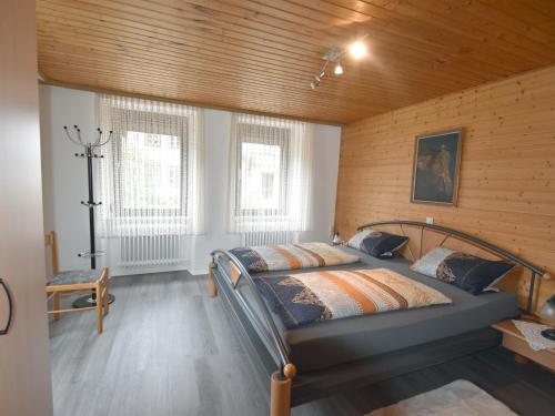 a bedroom with a bed and two windows at Landhaus Christina in Rumbach
