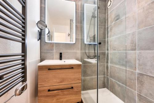 une salle de bain avec une douche, un lavabo et un miroir dans l'établissement Résidence Lacanau Les Pins - maeva Home - Appartement 2 pièces 4 personnes - Prestige MAE-6651, à Lacanau
