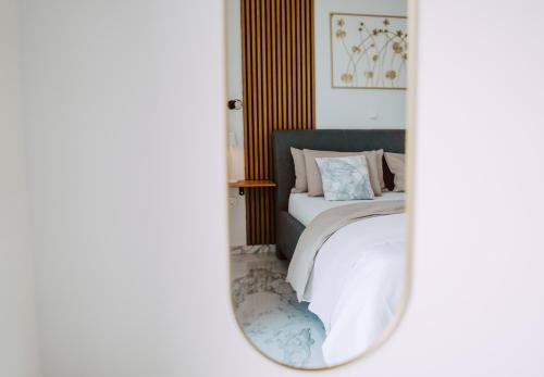 a bedroom with a bed and a mirror at Lili Rose Mandre Luxury Apartments in Mandre