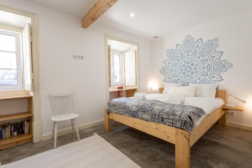 a bedroom with a bed and a chair in it at Joia - By Smarthomes in São Martinho do Porto