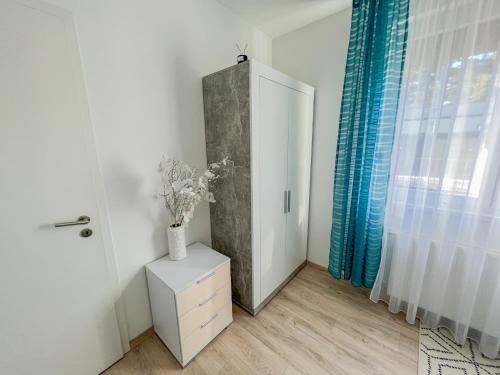 a room with a door and a vase of flowers on a cabinet at Relax Prémium Wellness Apartman in Siófok