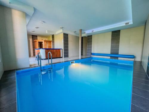 a swimming pool with blue lighting in a building at Relax Prémium Wellness Apartman in Siófok