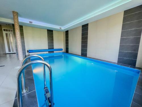 a lap pool in a room with a tile wall at Relax Prémium Wellness Apartman in Siófok