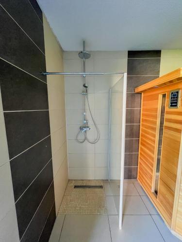 a shower with a glass door in a bathroom at Relax Prémium Wellness Apartman in Siófok