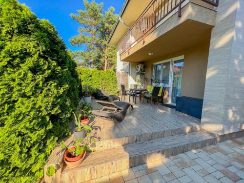 a house with a wooden deck with plants on it at Relax Prémium Wellness Apartman in Siófok
