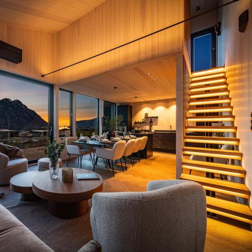 a living room with a staircase and a table and chairs at NEW! Spectacular cabin in Lofoten in Kleppstad