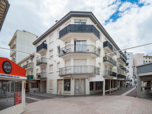 a white building with balconies on a street at T3 Vue Mer Clim Wifi Parking in Canet-en-Roussillon