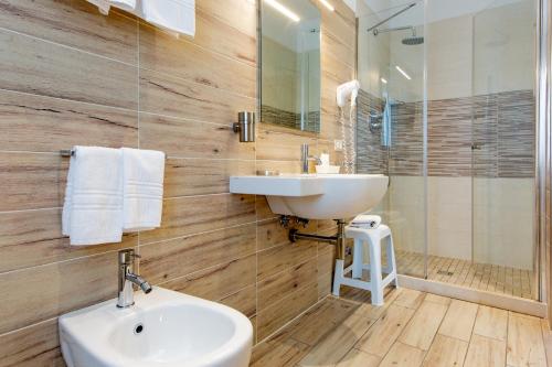 a bathroom with a sink and a toilet and a mirror at Hotel Lungomare in Cervia