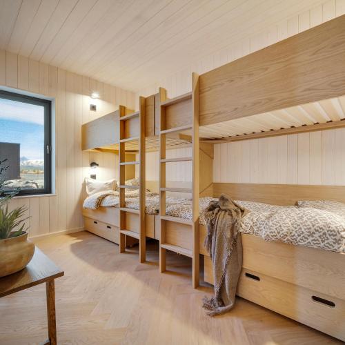 a bedroom with two bunk beds and a table at NEW! Spectacular cabin in Lofoten in Kleppstad