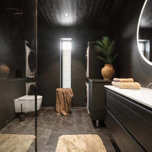 a black bathroom with a sink and a toilet at NEW! Spectacular cabin in Lofoten in Kleppstad