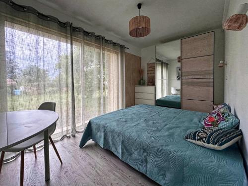 une chambre avec un lit, une table et des fenêtres dans l'établissement les chênes, à Rosières