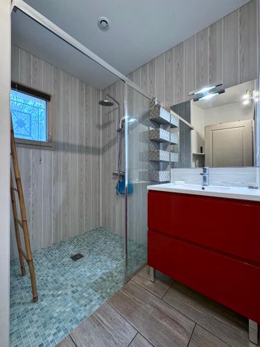 La salle de bains est pourvue d'un lavabo rouge et d'une douche. dans l'établissement les chênes, à Rosières