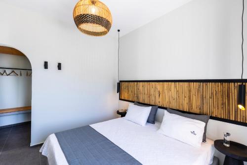 a bedroom with a white bed with a wooden headboard at William's Houses in Akrotiri